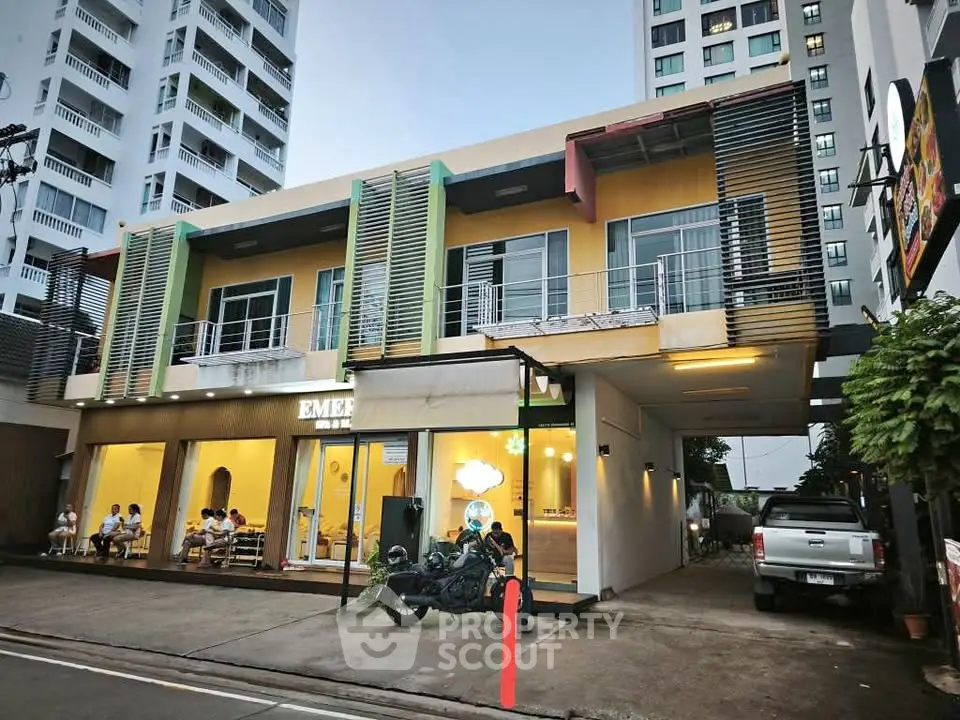 Modern commercial building with vibrant facade and street view, ideal for business opportunities.