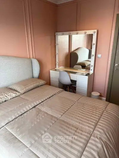 Cozy bedroom with elegant vanity and plush bedding in a stylish apartment.