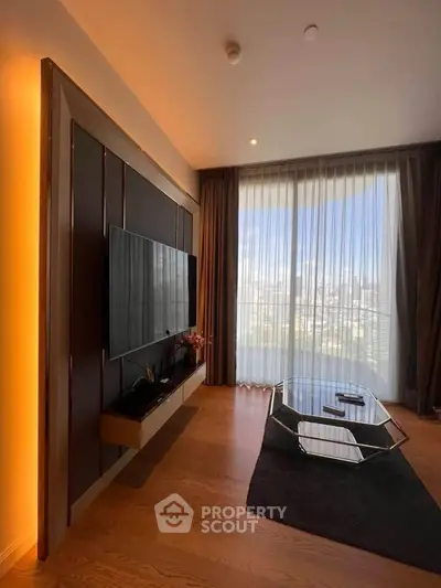 Modern living room with large TV, stylish decor, and floor-to-ceiling windows offering city views.
