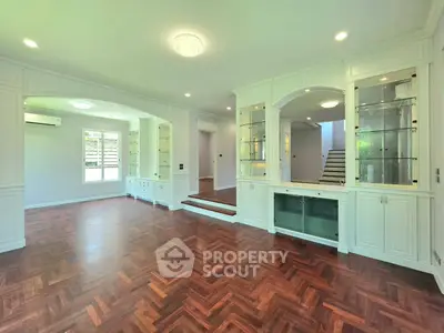 Spacious living room with elegant built-in cabinets and hardwood flooring