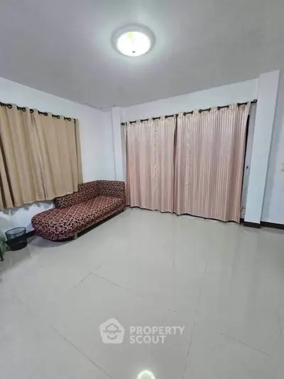 Spacious living room with elegant curtains and stylish sofa in modern apartment.