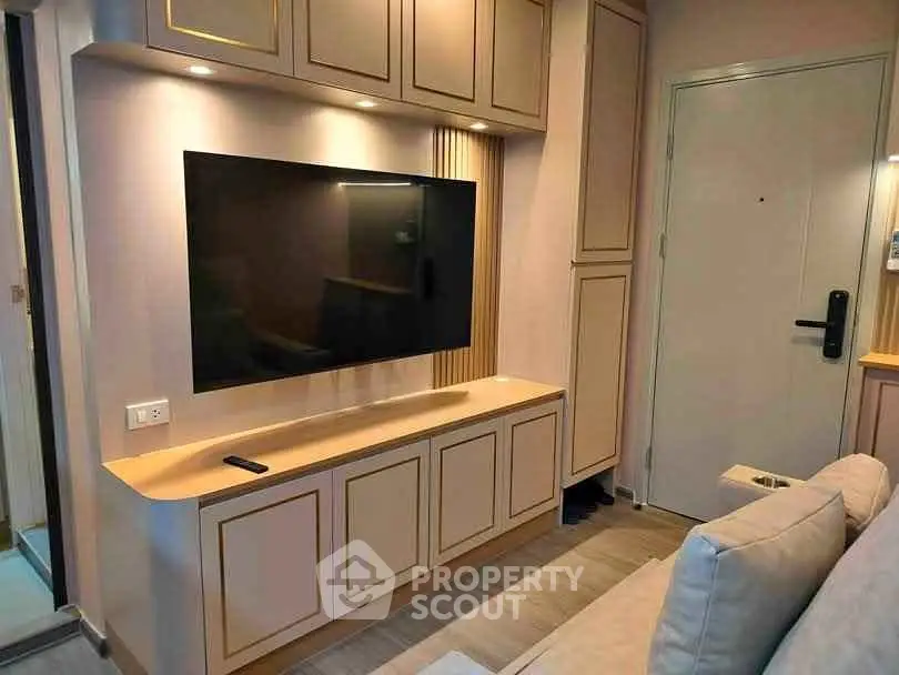 Modern living room with sleek TV setup and stylish cabinetry in a cozy apartment.