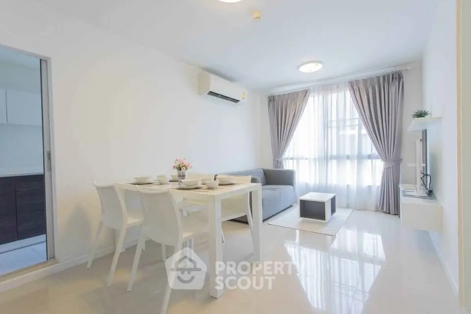 Bright and modern living room with dining area and large window, perfect for cozy gatherings.