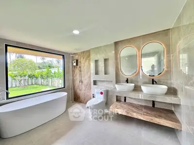 Luxurious modern bathroom with dual sinks and garden view