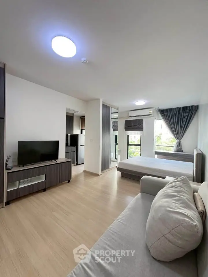 Modern open-plan living room with natural light and stylish furnishings in a contemporary apartment.