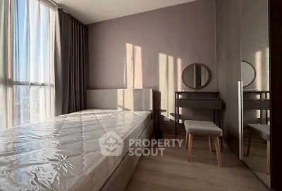 Modern bedroom with natural light, stylish furniture, and floor-to-ceiling windows.