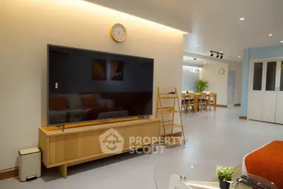 Spacious modern living room with large TV and stylish dining area
