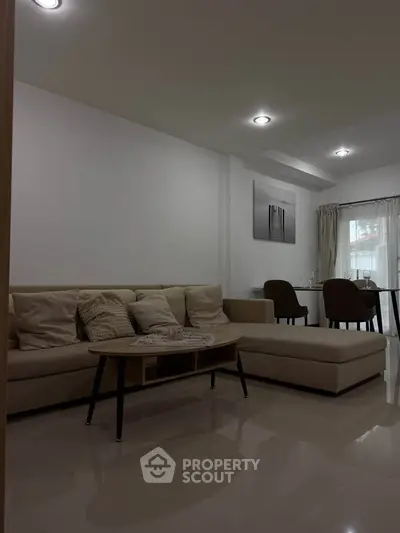 Modern living room with cozy beige sofa and elegant dining area, perfect for stylish urban living.