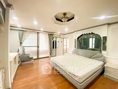 Spacious bedroom with elegant decor and large windows for natural light
