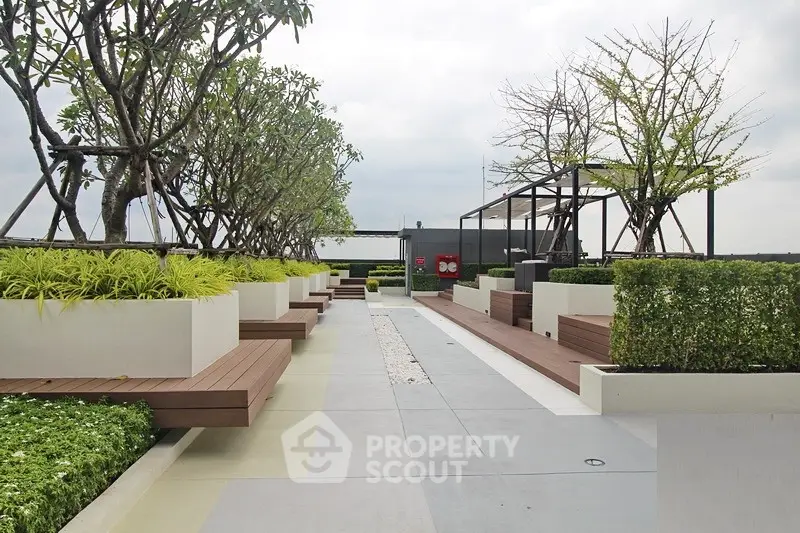 Modern rooftop garden with stylish seating and lush greenery