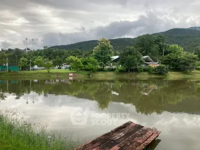 Scenic view of a tranquil lake with lush greenery and mountains in the background, perfect for serene living.