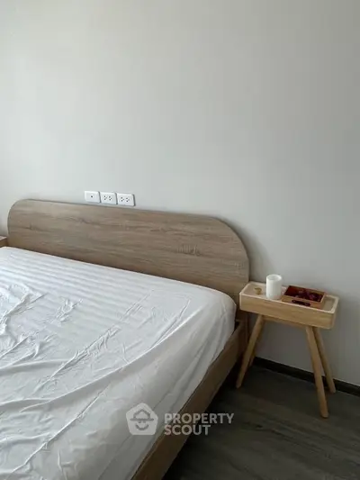 Modern minimalist bedroom with wooden bed and side table