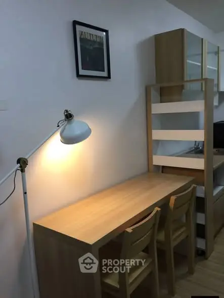 Cozy study area with wooden desk and chairs, perfect for productivity.