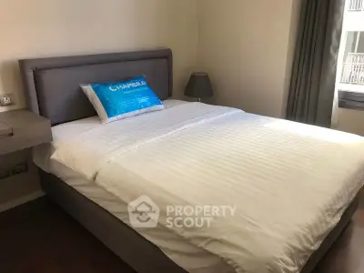 Cozy bedroom with modern decor and natural light in a stylish apartment.