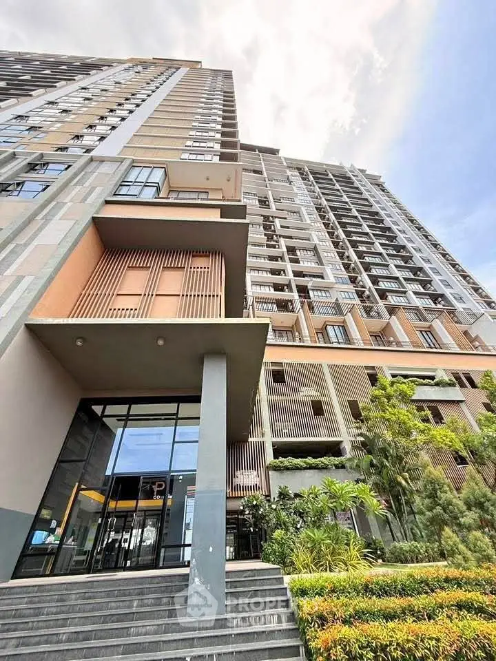 Modern high-rise building with lush landscaping and sleek entrance