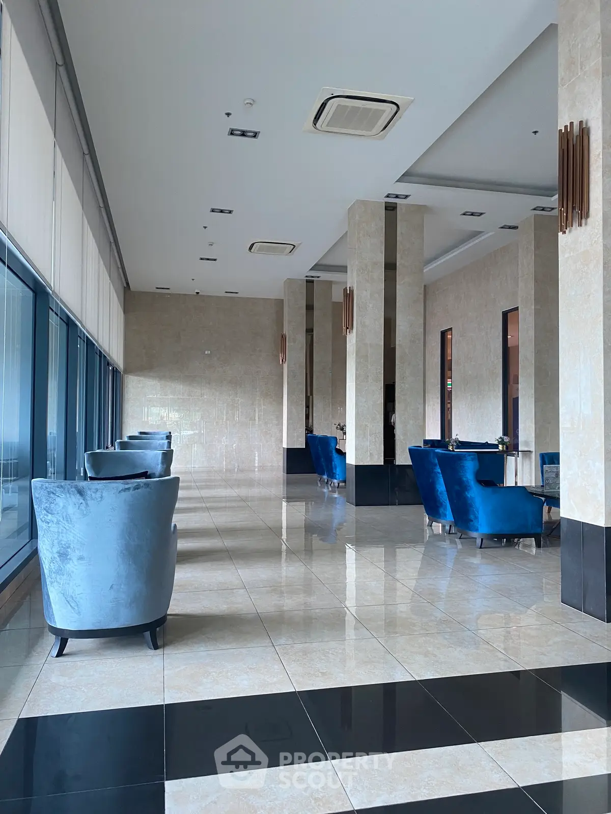 Luxurious lobby with elegant seating and polished marble floors in a modern building.