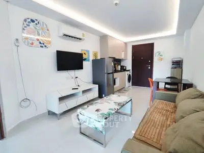 Modern open-plan living room with kitchen, featuring sleek furniture and contemporary decor.