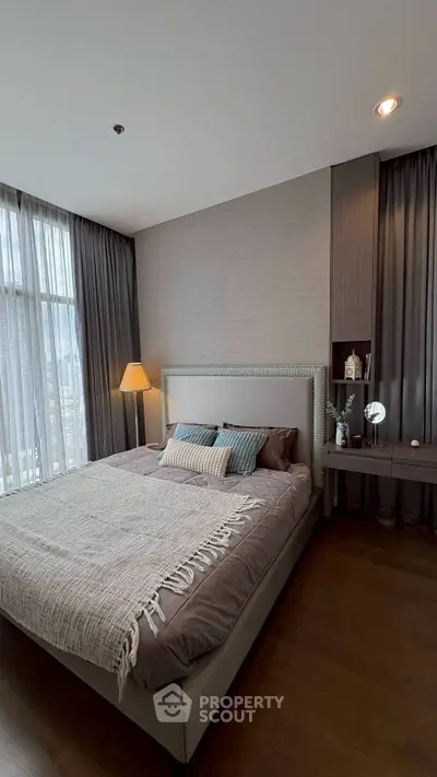 Luxurious bedroom with modern decor and large windows offering stunning city views.