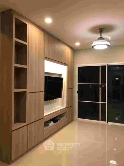 Modern living room with built-in wooden shelves and sleek lighting