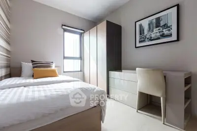 Modern bedroom with sleek furniture and natural light in a stylish apartment.