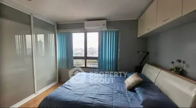 Modern bedroom with city view, featuring sleek design and ample natural light.