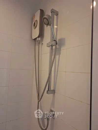 Modern bathroom shower with sleek design and water heater in a stylish tiled setting.