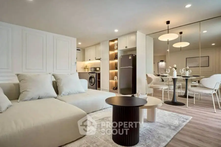 Modern open-plan living room with stylish furniture and kitchen appliances