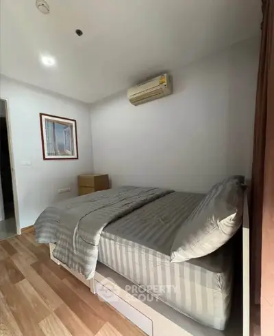 Cozy bedroom with modern air conditioning and stylish decor in a well-lit apartment.