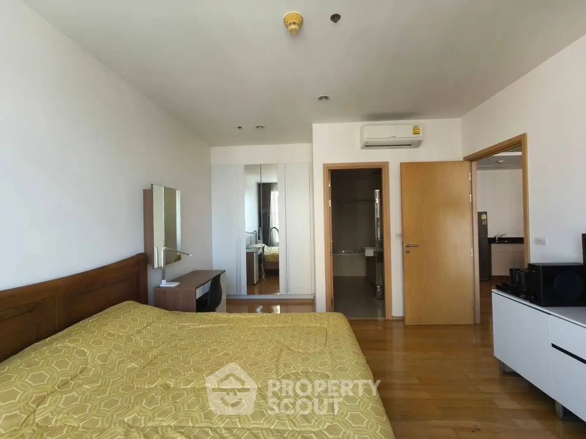 Spacious bedroom with modern decor and wooden flooring