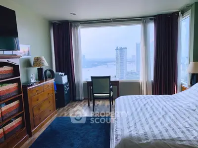 Spacious bedroom with stunning city and river view, featuring modern decor and ample natural light.