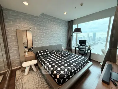 Modern bedroom with city view, stylish decor, and workspace in luxury apartment.
