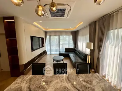 Luxurious modern living room with elegant furnishings and large windows.