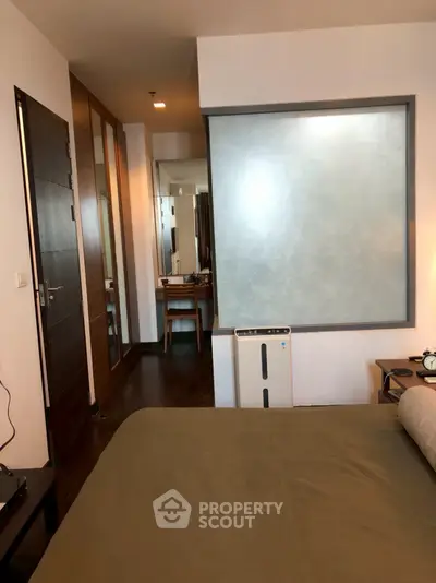 Modern bedroom with sleek design and ensuite bathroom, featuring a stylish partition wall.