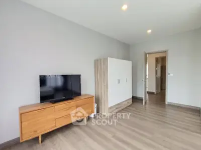 Spacious modern living room with sleek wooden furniture and flat-screen TV, perfect for relaxation.