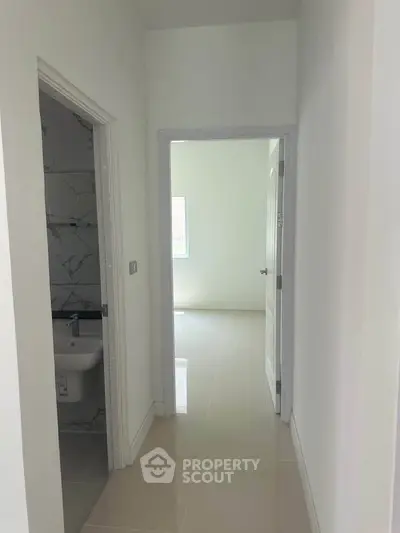 Bright hallway with bathroom and room entrance, showcasing modern minimalist design.