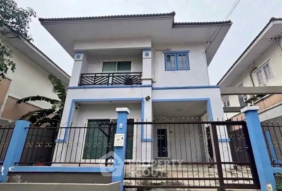 Charming two-story house with modern design and gated entrance in a serene neighborhood.