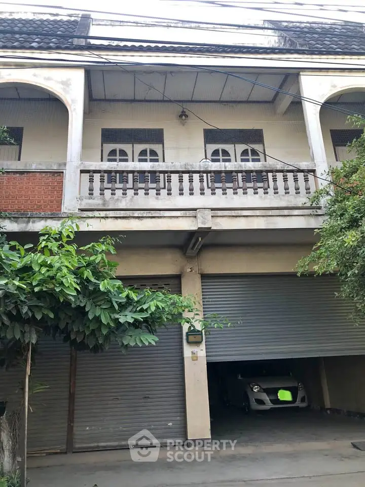 Charming multi-story building with garage and balcony in urban setting.