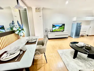 Modern living room with dining area, stylish decor, and sleek appliances in a cozy apartment.