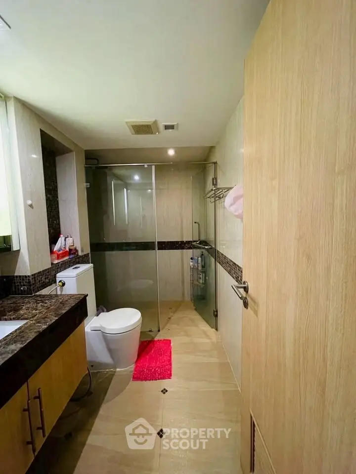 Modern bathroom with glass shower and wooden accents
