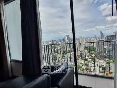 Stunning cityscape view from a high-rise balcony with modern seating, perfect for urban living.