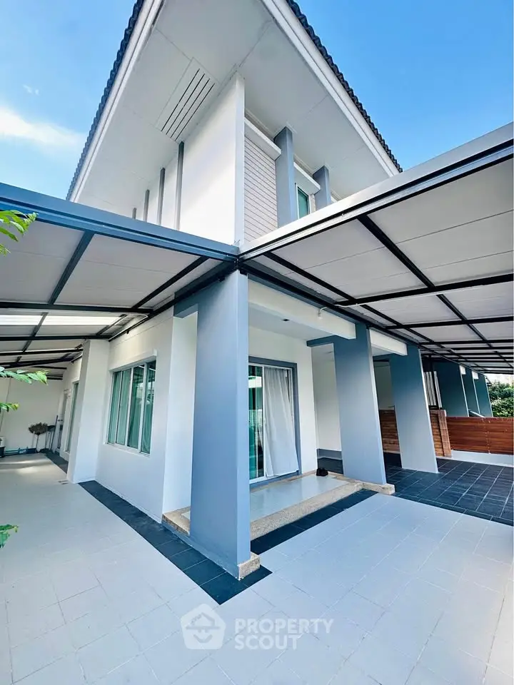 Modern two-story house with sleek design and spacious outdoor area, perfect for family living.