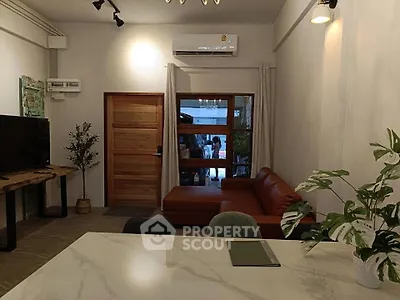 Modern living room with stylish furniture and air conditioning, featuring a cozy sofa and elegant decor.