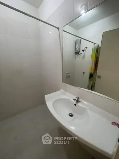 Spacious bathroom with modern sink and large mirror in a contemporary apartment.