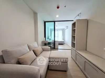 Modern apartment interior with cozy living room and view into bedroom
