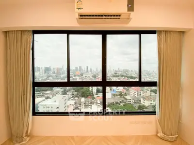 Spacious apartment with panoramic city view through large windows, featuring elegant curtains and modern air conditioning.