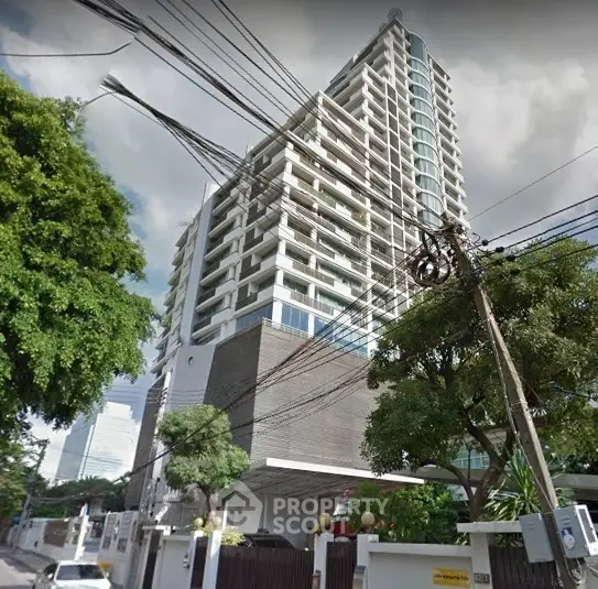 Modern high-rise building with spacious balconies and lush greenery