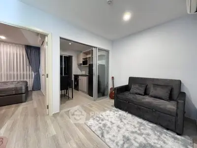 Modern open-plan living room with cozy sofa and sleek kitchen