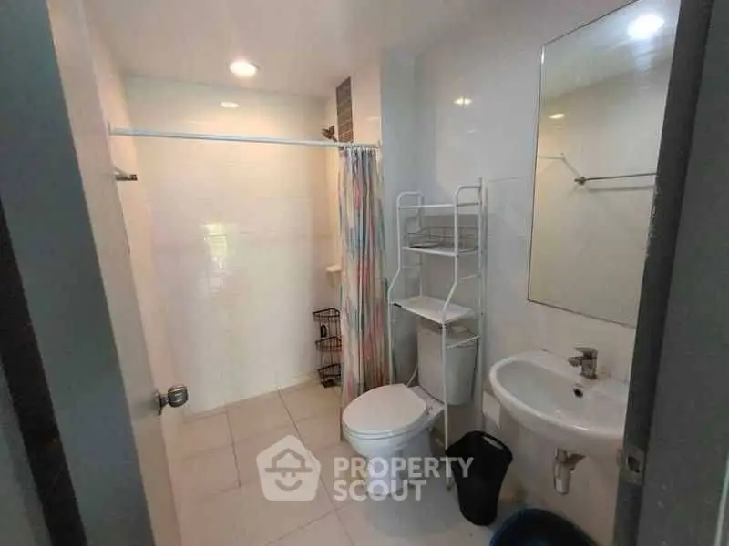 Modern bathroom with shower, toilet, and sink in a compact layout.