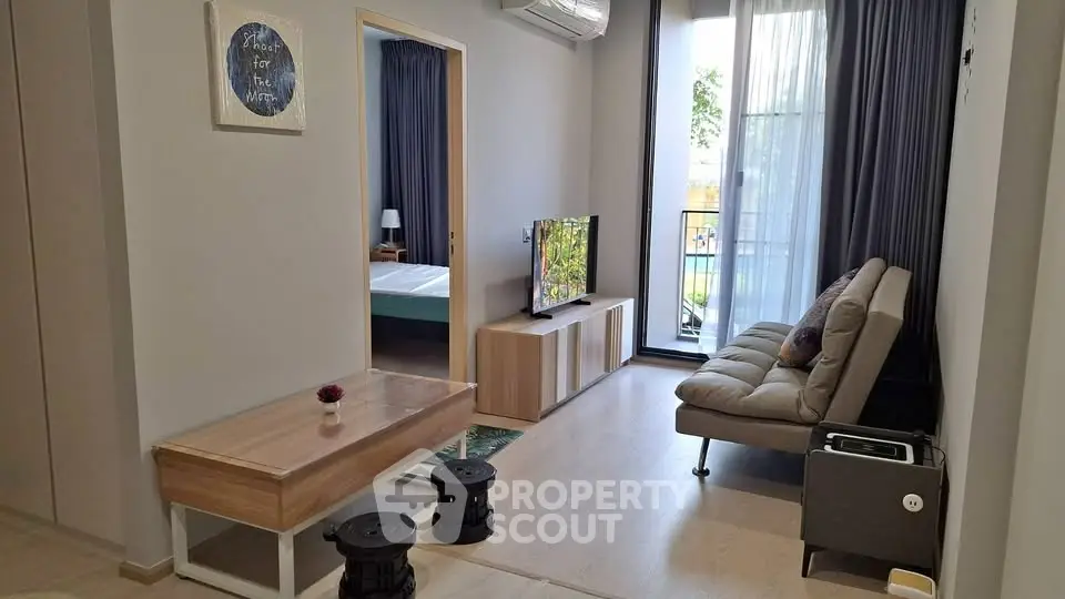 Modern living room with stylish decor and balcony access in a cozy apartment.