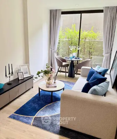 Stylish living room with modern decor and large window overlooking greenery, perfect for relaxation.